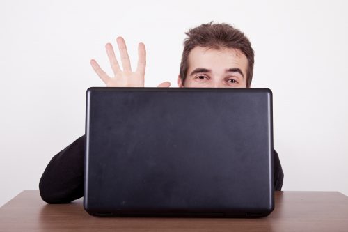 Mann versteckt sich hinter Computer und Ausreden